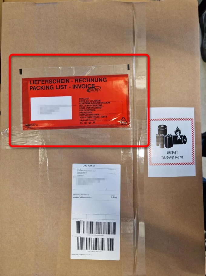 außen am Karton klebt eine Versandtasche, in der sich die Rechnung befindet